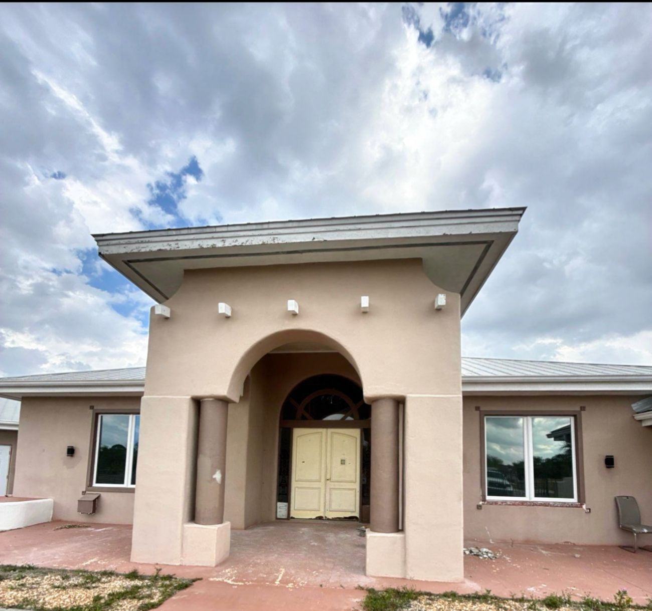 Faded stucco home entry before repaint