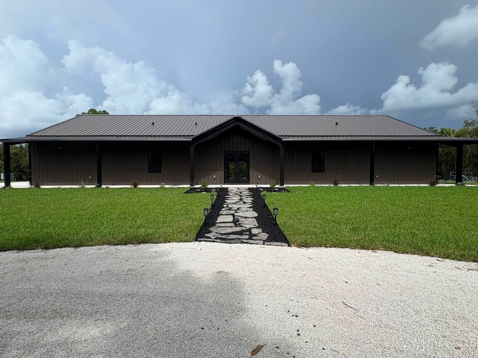 Dark brown board and batten home with metal roof