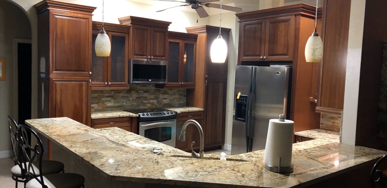 Kitchen before: dark stained wood cabinets